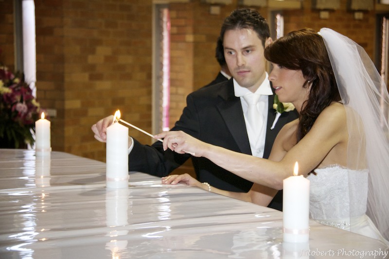 Lighting the marriage candle during the catholic wedding ceremony - wedding photography sydney